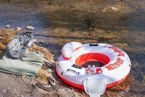 Lifestyle photo of Pittman RD1-ICE inflatable one person river drifter with ice chest on river beach
